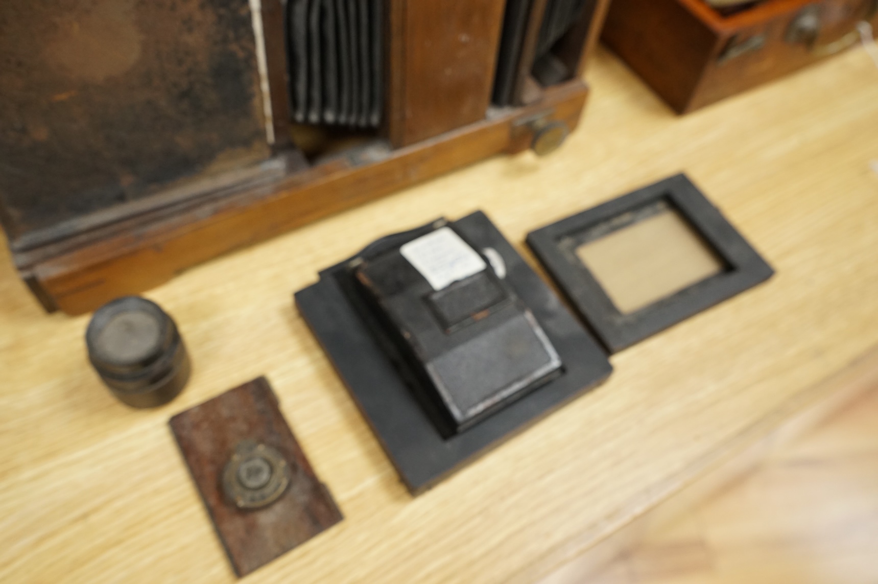 A late 19th century mahogany and tinplate magic lantern style horizontal photograph enlarger, together with some related items.